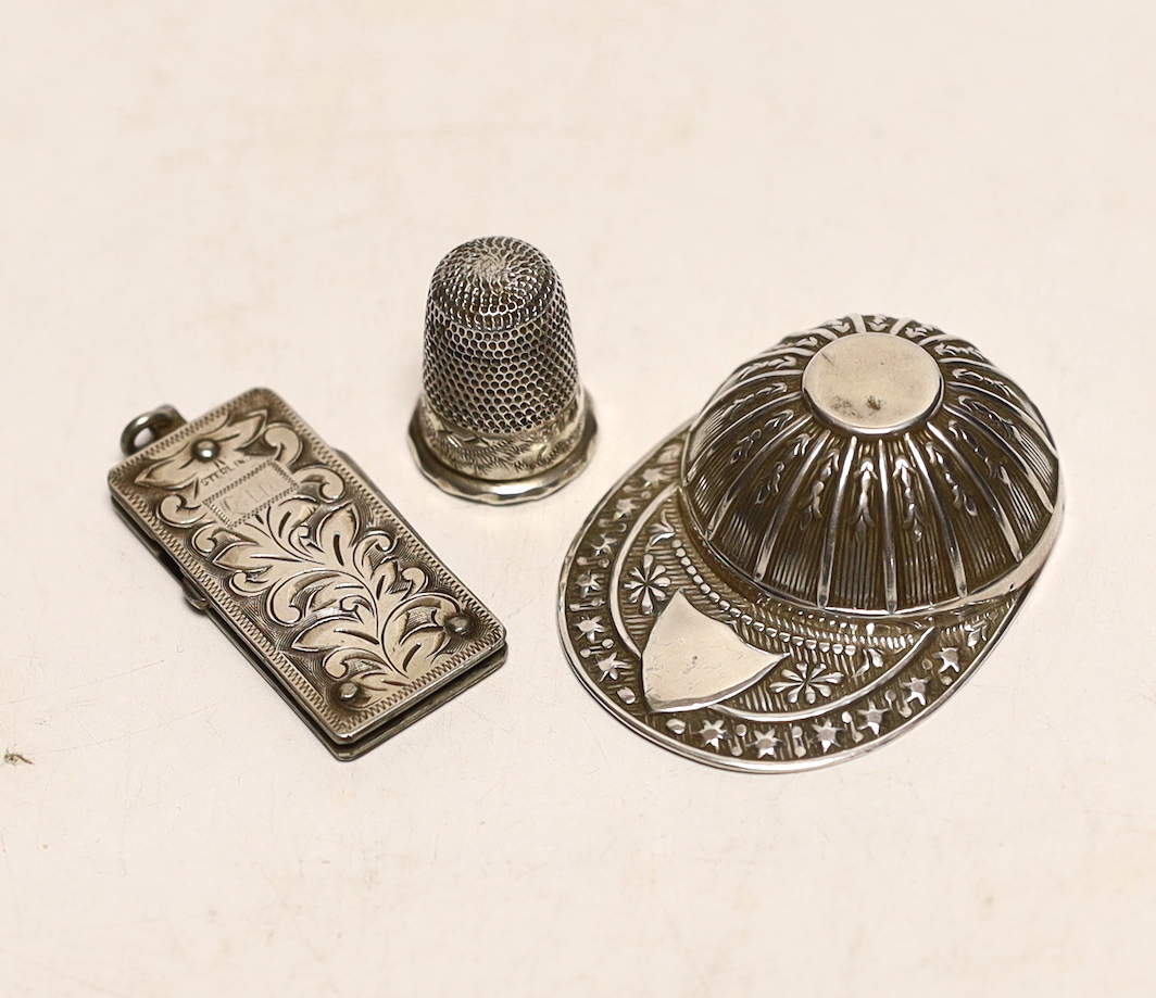 An unmarked white metal caddy spoon, modelled as a jockey's cap, 52mm, together with a silver thimble and silver mounted pocket knife.